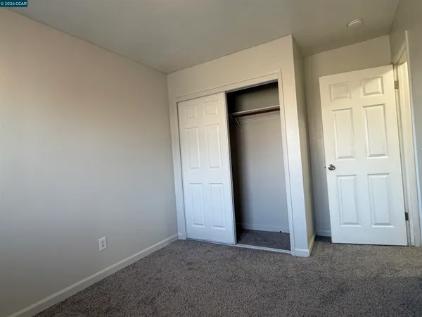 an empty room with closet area