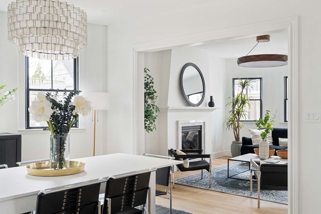 a living room with furniture a fireplace and potted plants