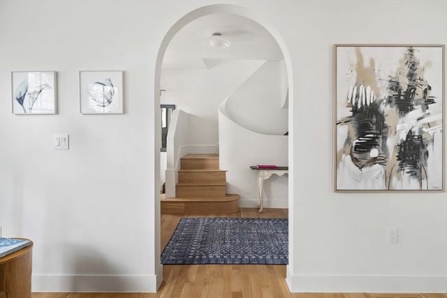 a view of a hallway with wooden floor and entryway
