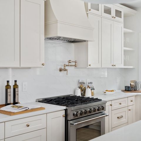 a kitchen with white cabinets and appliances