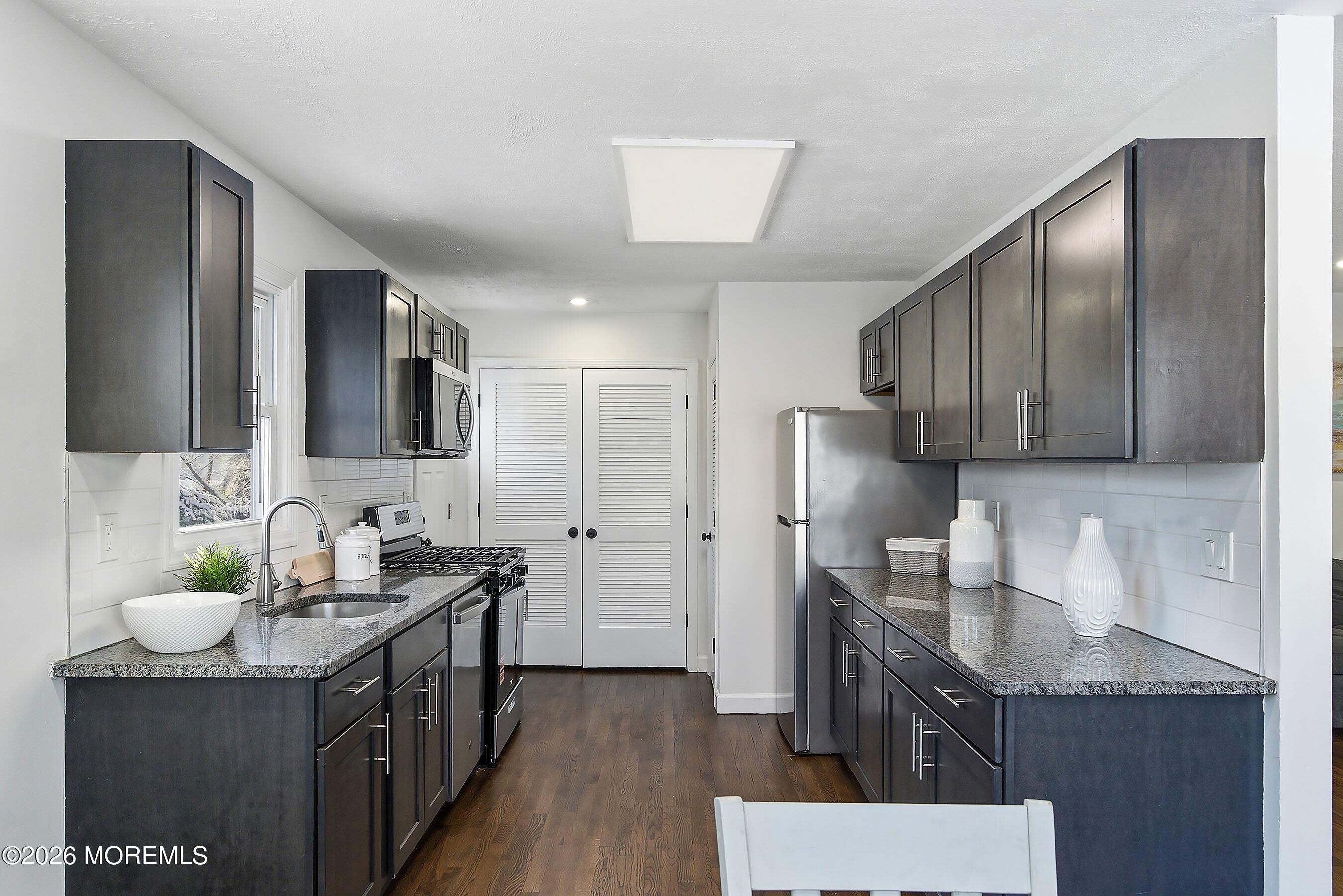 123 West 4th Street Howell, NJ 07731 - Photo 13 of 25 a kitchen with stainless steel appliances granite countertop a sink stove and refrigerator
