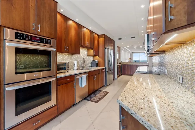 a kitchen with stainless steel appliances granite countertop a stove a sink and a microwave