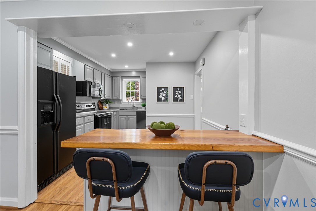 1008 Bevridge Road Richmond, VA 23226 - Photo 9 of 43 a kitchen with stainless steel appliances granite countertop a sink a stove a refrigerator a microwave oven with white cabinets and wooden floor