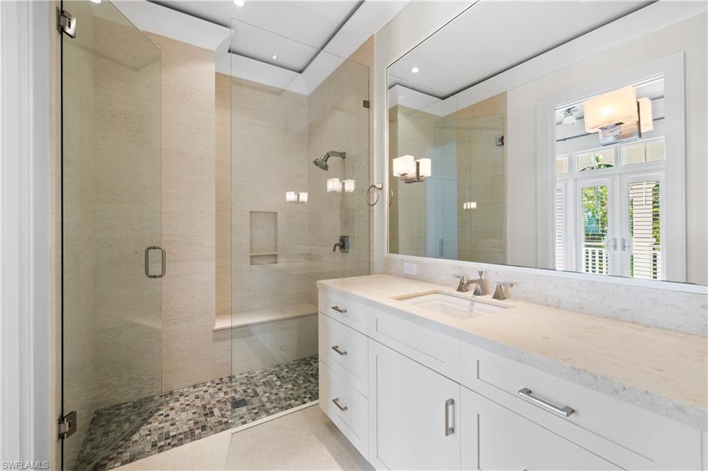 1270 Gulf Shore Boulevard South Naples, FL 34102 - Photo 14 of 24 a bathroom with a shower sink and mirror