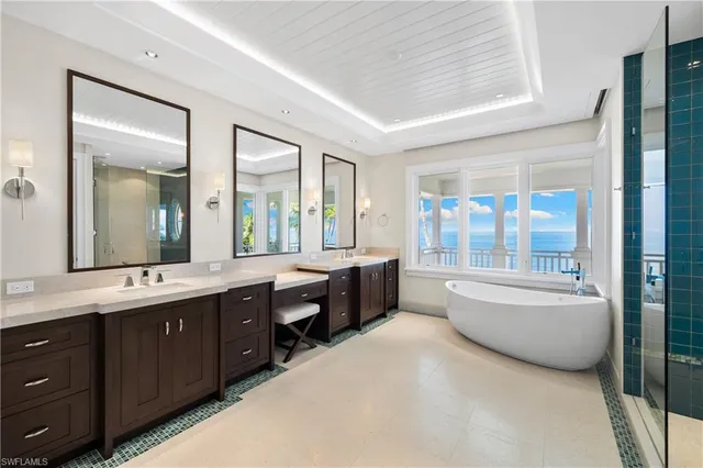 a large spacious bathroom with a granite countertop tub a double vanity sink a mirror and a bathtub