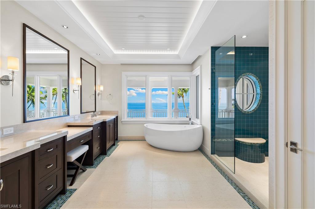 1270 Gulf Shore Boulevard South Naples, FL 34102 - Photo 19 of 24 a large spacious bathroom with a granite countertop tub a double vanity sink a mirror and a bathtub