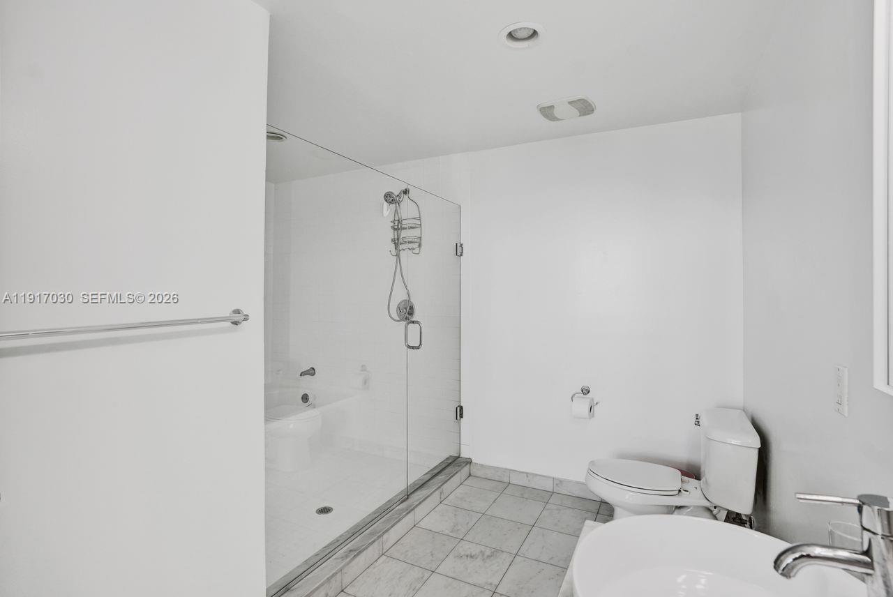 888 Biscayne Boulevard, Unit 2904 Miami, FL 33132 - Photo 11 of 27 a bathroom with a granite countertop toilet and a shower