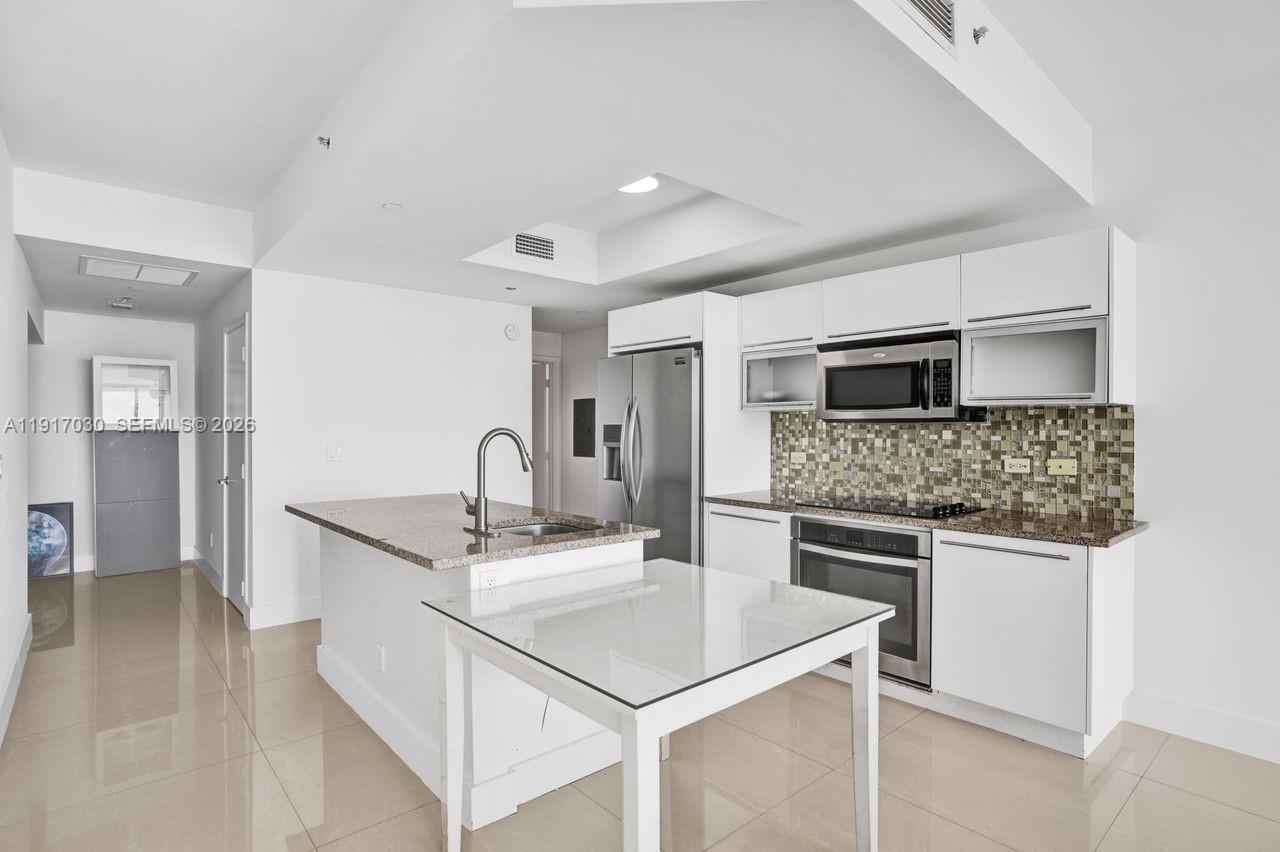 888 Biscayne Boulevard, Unit 2904 Miami, FL 33132 - Photo 4 of 27 a kitchen with a sink stove and microwave