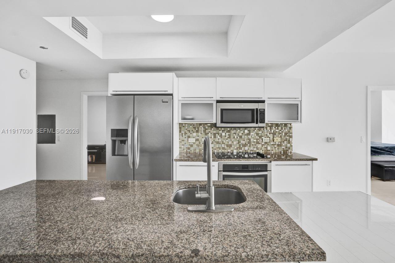 888 Biscayne Boulevard, Unit 2904 Miami, FL 33132 - Photo 5 of 27 a kitchen with stainless steel appliances granite countertop a sink stove and refrigerator