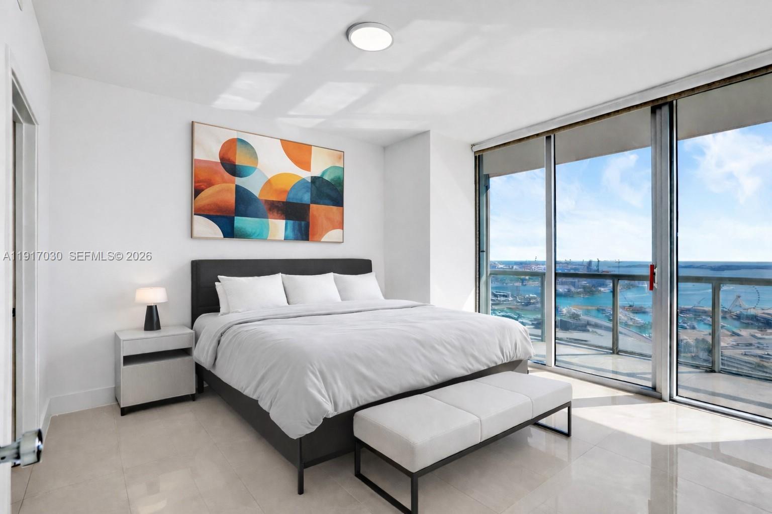 888 Biscayne Boulevard, Unit 2904 Miami, FL 33132 - Photo 8 of 27 a spacious bedroom with a bed and glass window