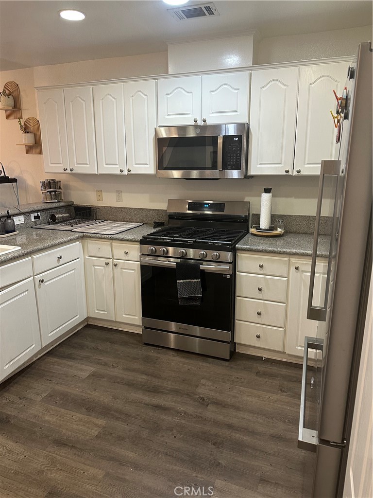 220 West Walnut Avenue, Unit B Rialto, CA 92376 - Photo 7 of 14 a kitchen with granite countertop a stove top oven microwave and cabinets