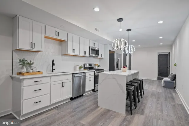 a kitchen that has a lot of cabinets in it and wooden floors