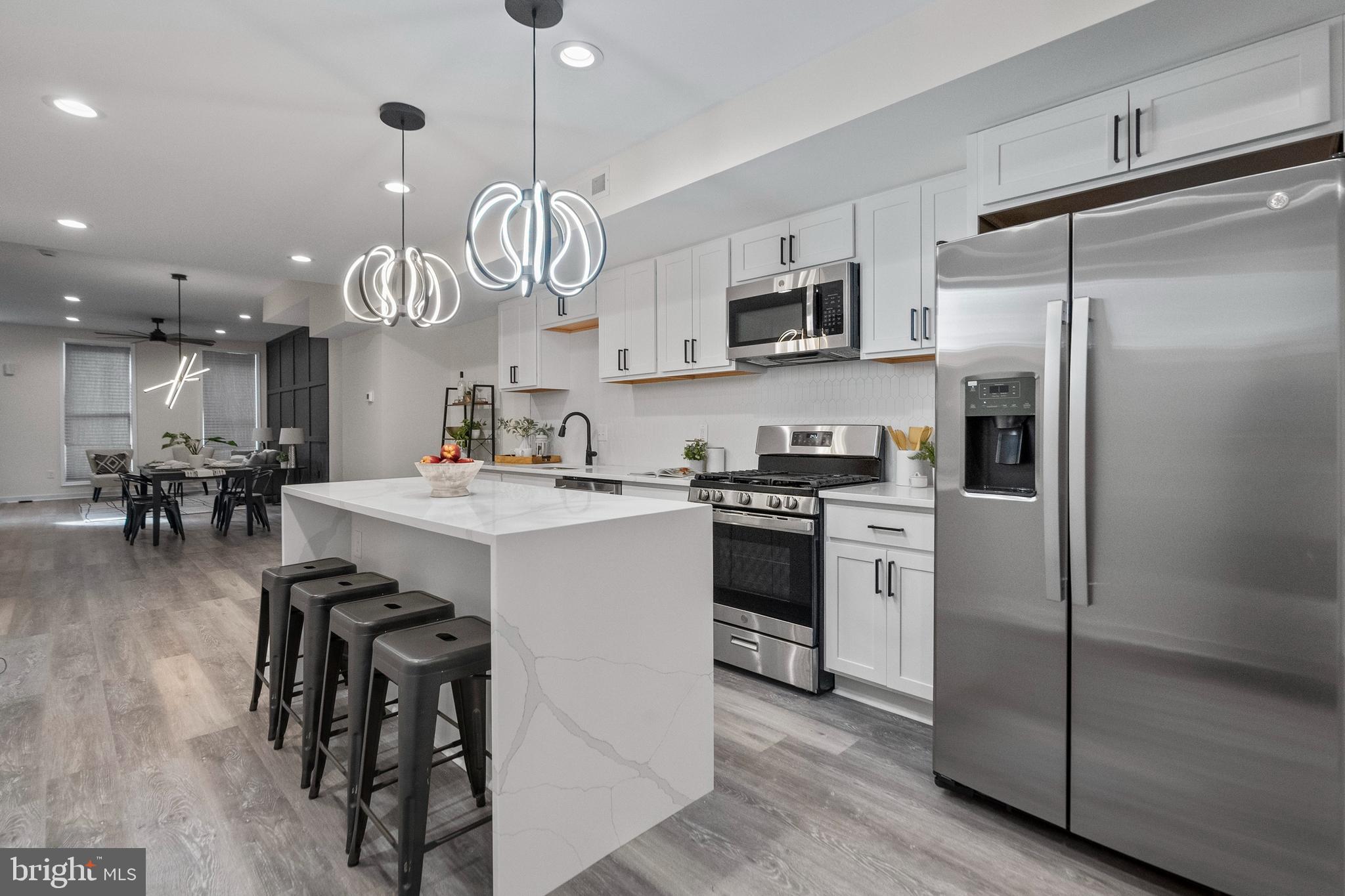 2141 Druid Hill Avenue Baltimore, MD 21217 - Photo 5 of 11 a kitchen with stainless steel appliances a refrigerator a stove microwave and cabinets