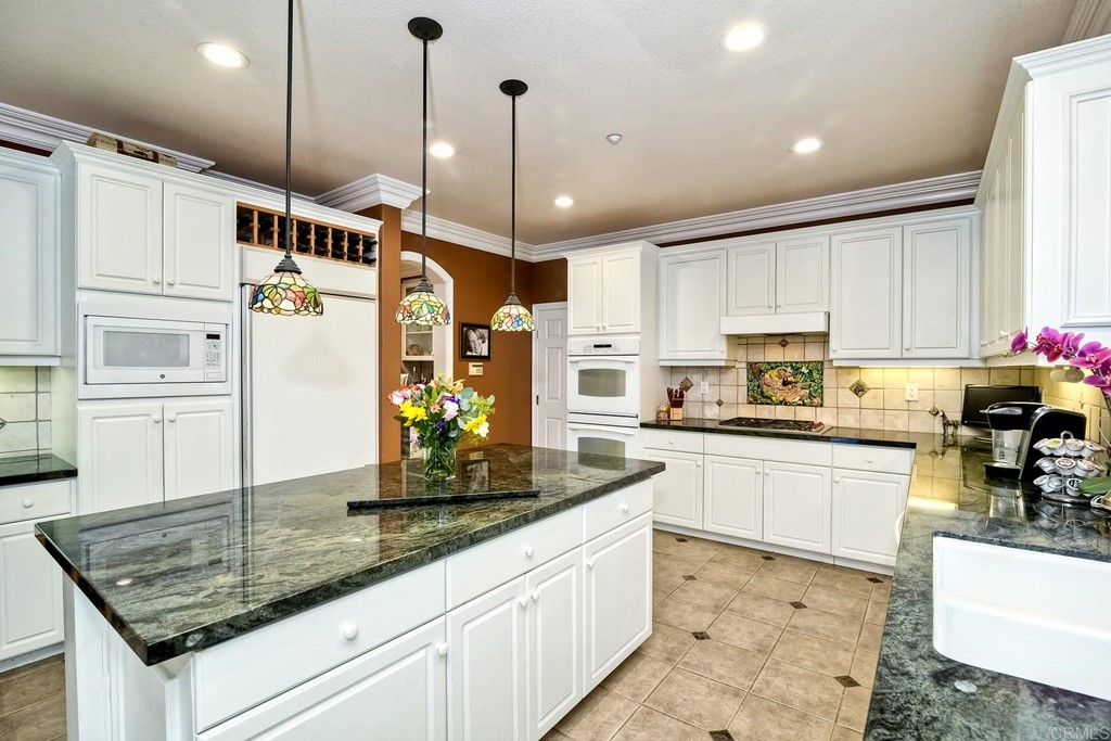 710 West Bluff Drive Encinitas, CA 92024 - Photo 5 of 12 a kitchen with stainless steel appliances granite countertop a sink a stove a refrigerator and cabinets