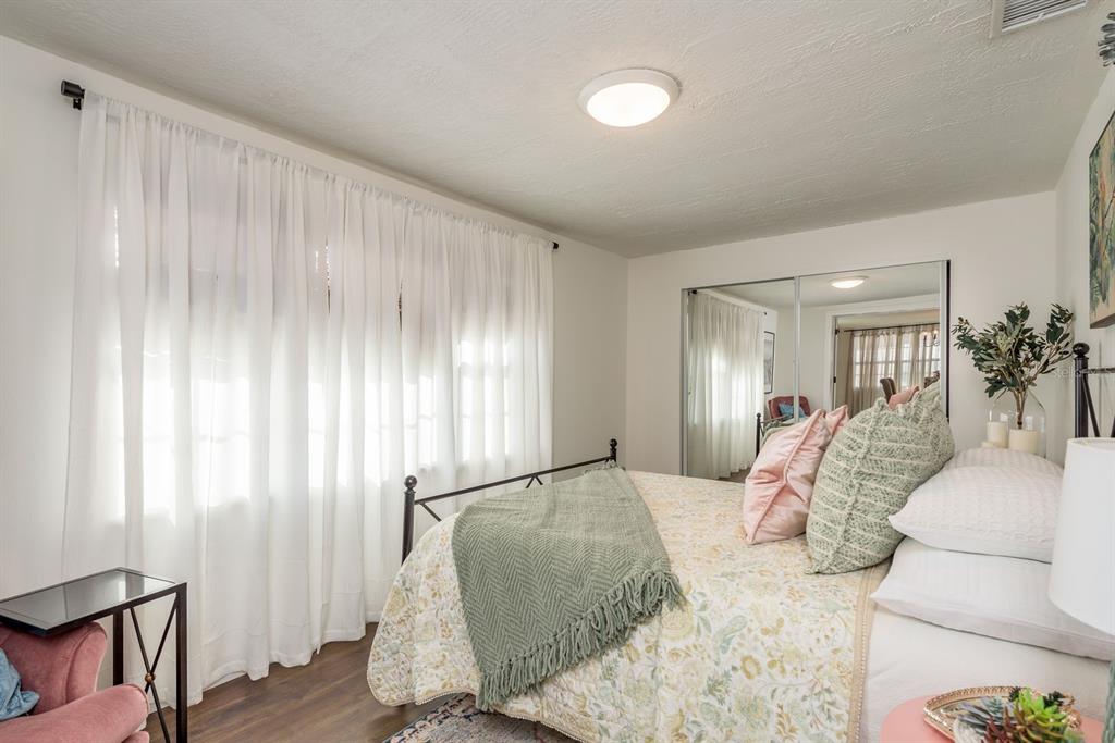 9110 Rainbow Lane Port Richey, FL 34668 - Photo 21 of 29 a bedroom with a large bed and a chandelier