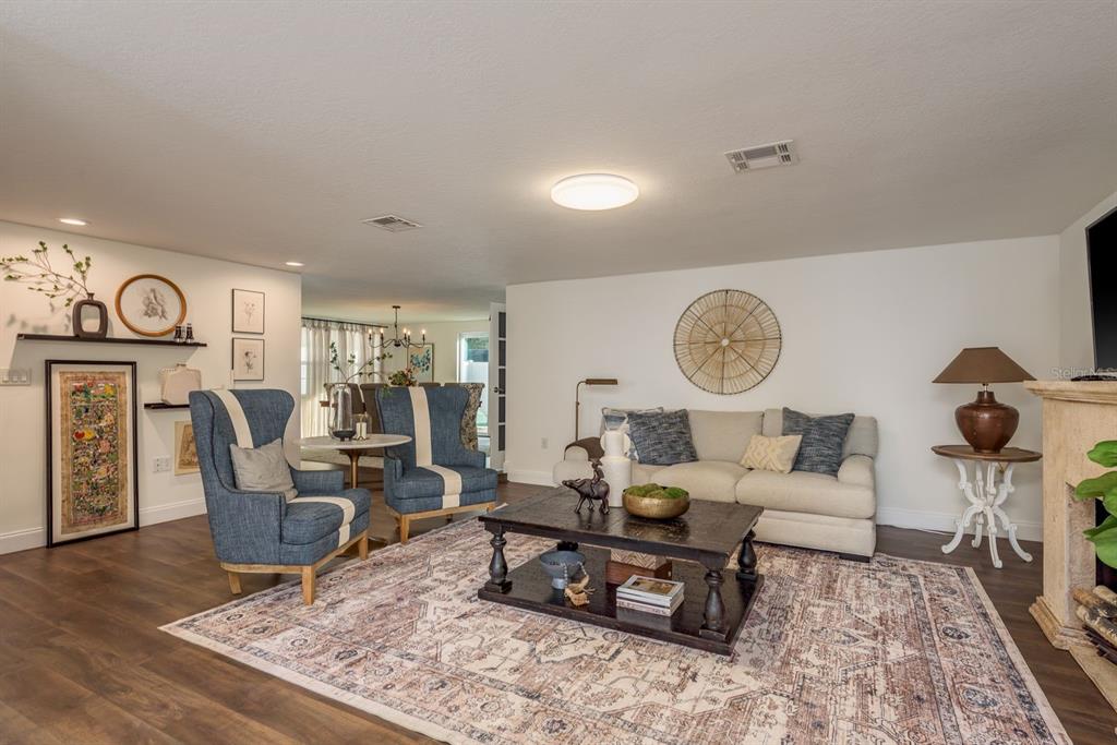 9110 Rainbow Lane Port Richey, FL 34668 - Photo 9 of 29 a living room with furniture a clock on wall and a table