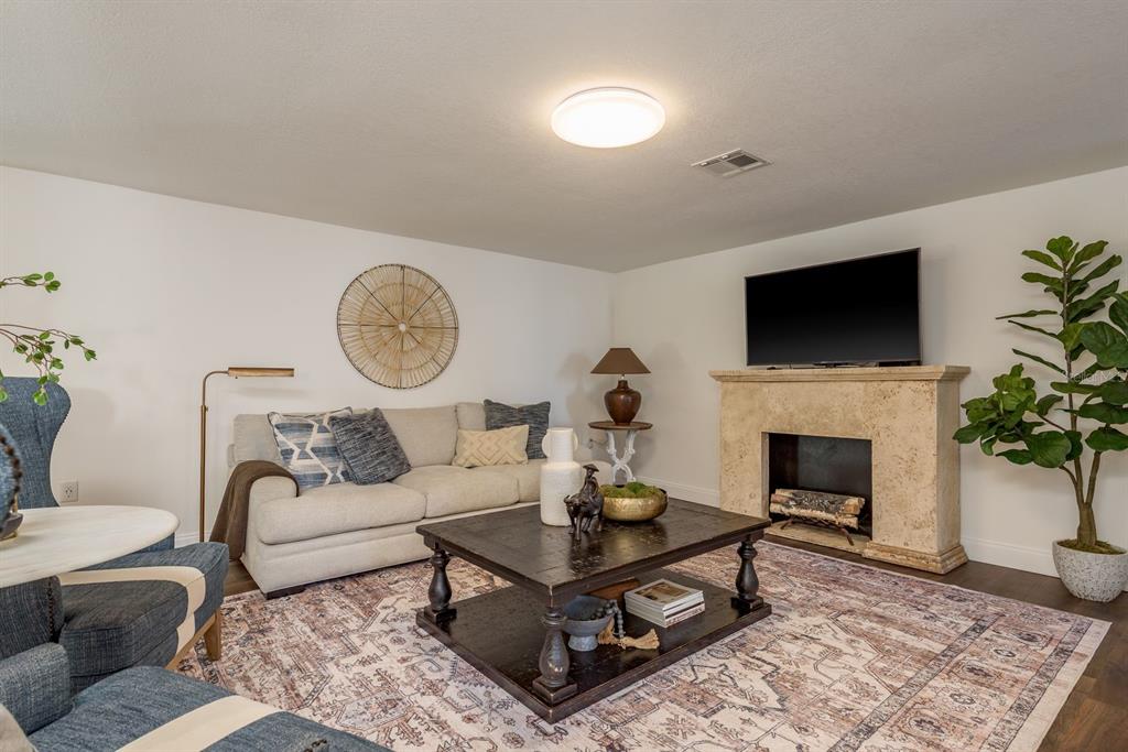 9110 Rainbow Lane Port Richey, FL 34668 - Photo 10 of 29 a living room with furniture a rug and a fireplace