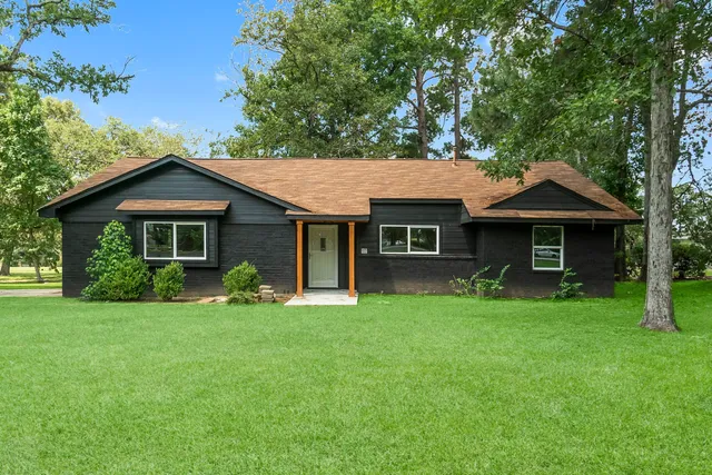 a front view of a house with a yard and trees