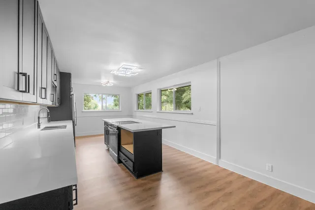 an open kitchen with granite countertop a stove and a sink