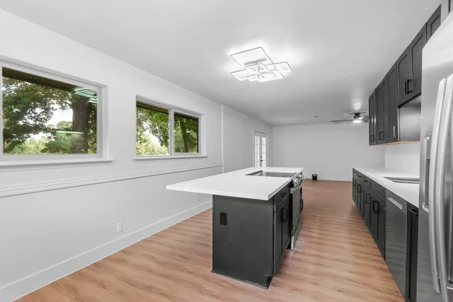 a kitchen with a stove a sink and wooden floor