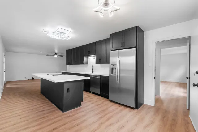 a kitchen with stainless steel appliances granite countertop a refrigerator and a sink