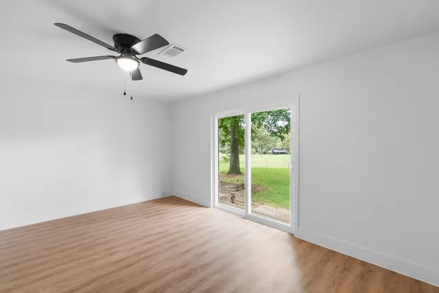 wooden floor in an empty room with a window
