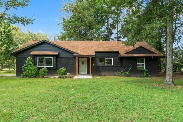 a front view of a house with a yard and trees