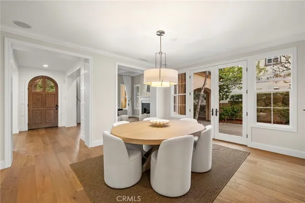 a kitchen with stainless steel appliances kitchen island granite countertop a dining table chairs and white cabinets