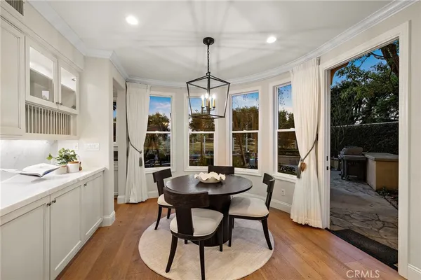 a bedroom with a bed large window with table and chair