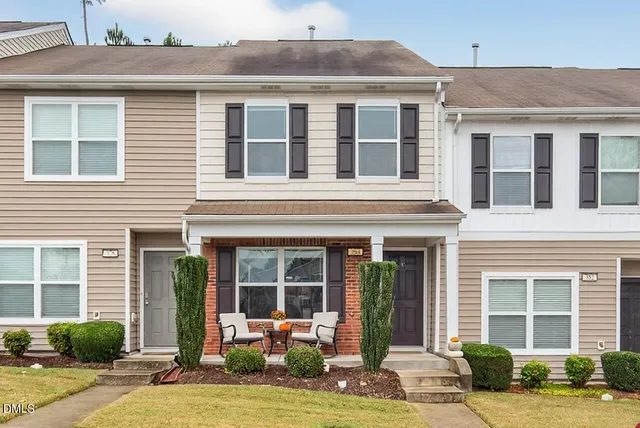a front view of a house with garden and plants