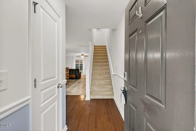 a view of a hallway with wooden floor and staircase