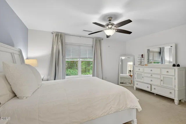 a bedroom with a large bed and a chandelier