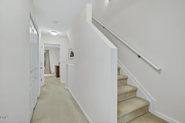 a view of a hallway with staircase and white walls