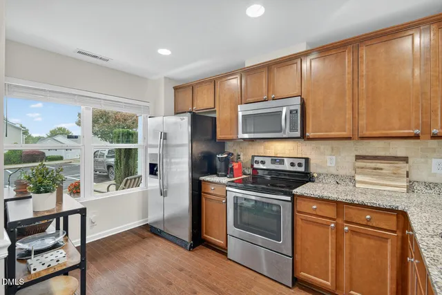 a kitchen with stainless steel appliances granite countertop a refrigerator stove microwave and sink