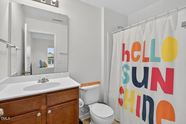 a bathroom with a sink toilet and curtain