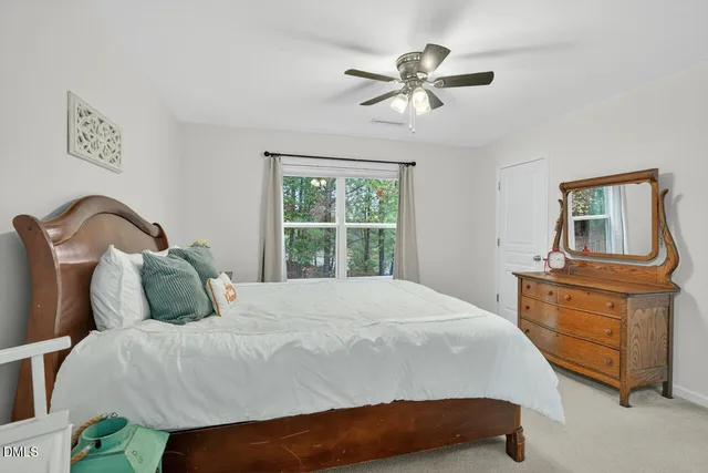 a bedroom with a bed and dresser with mirror