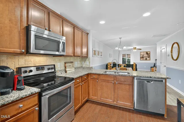 a kitchen with stainless steel appliances granite countertop a sink stove and microwave