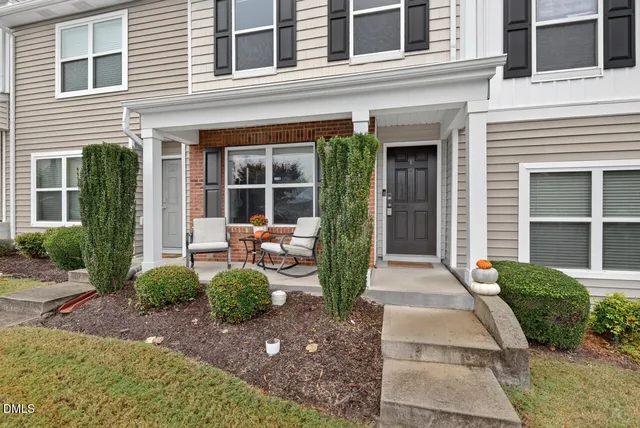a front view of a house with garden and plants