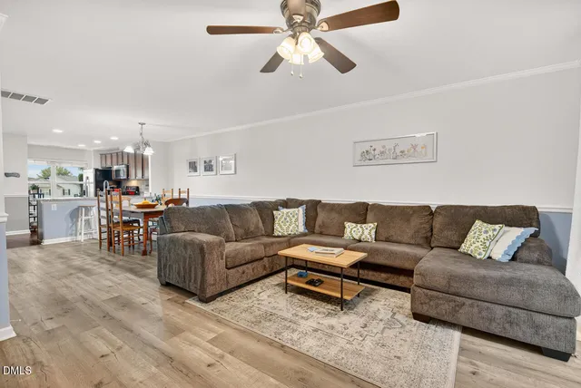 a living room with furniture and a view of kitchen
