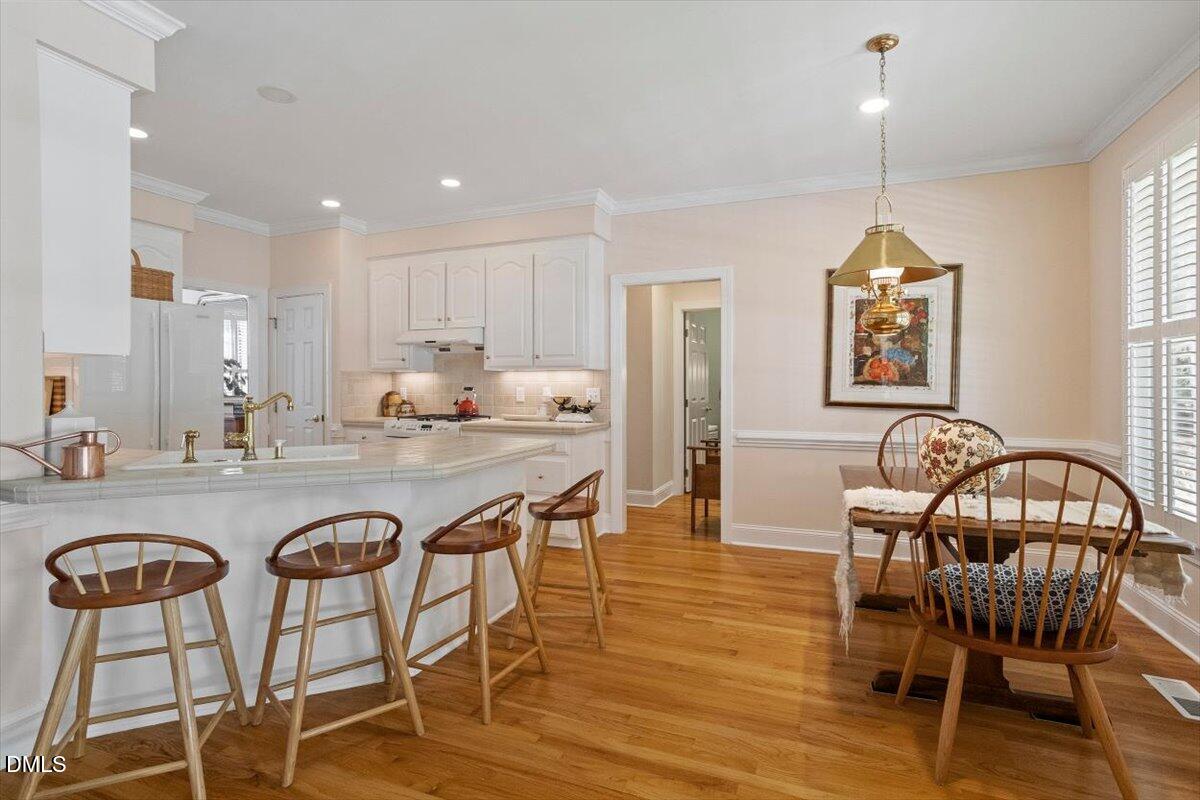 9108 Hometown Drive Raleigh, NC 27615 - Photo 22 of 41 a dining room with furniture a chandelier and wooden floor