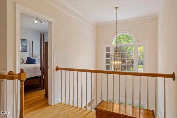 a view of a hallway with wooden floor and a bathroom