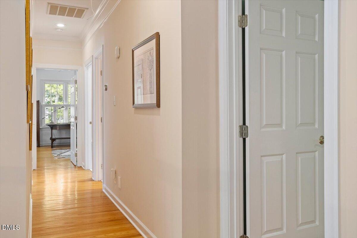 9108 Hometown Drive Raleigh, NC 27615 - Photo 32 of 41 a view of a hallway with wooden floor and a bathroom