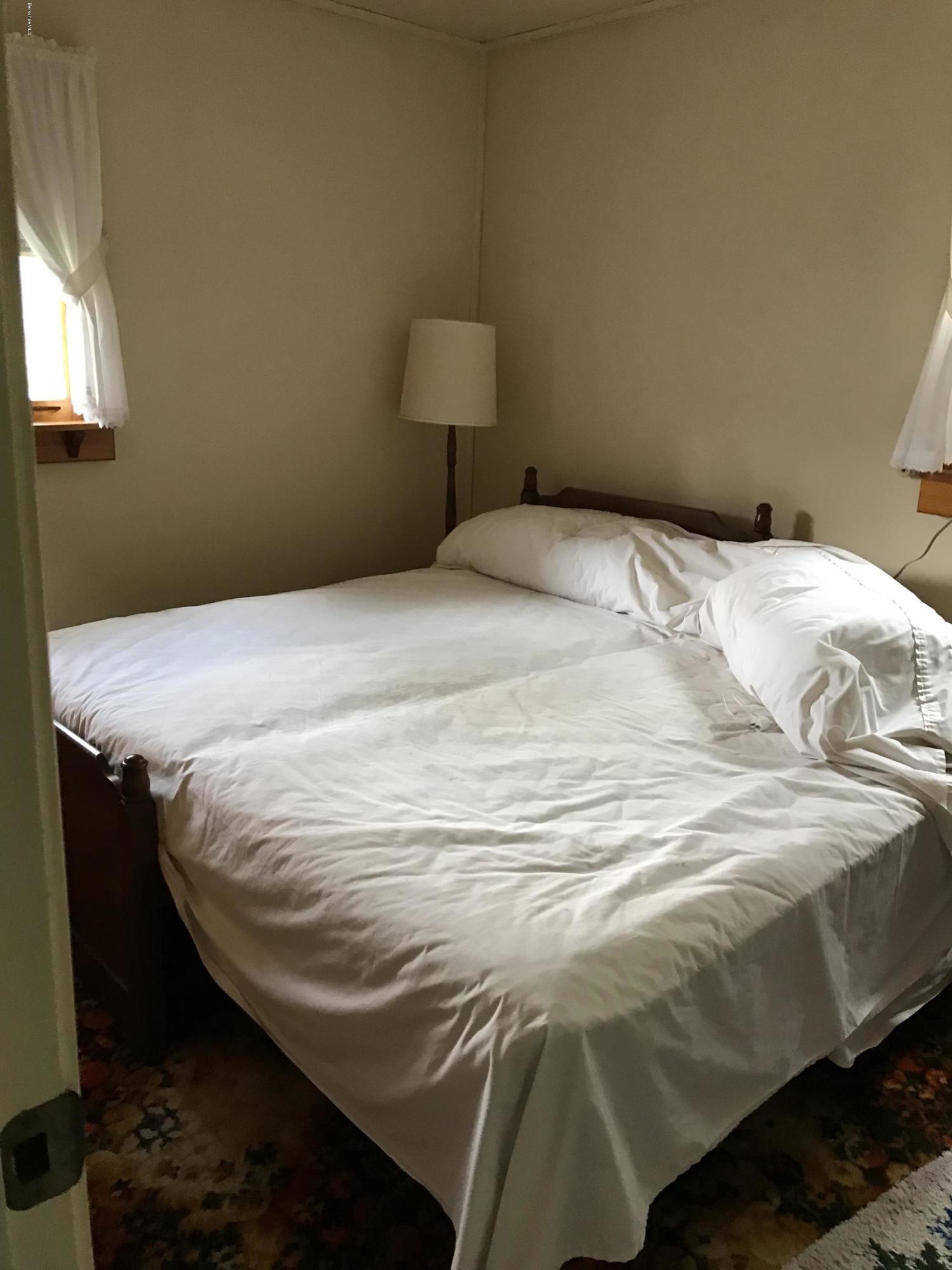 120 Tyringham Road Lee, MA 01238 - Photo 3 of 7 a bed sitting in a bedroom with a lamp