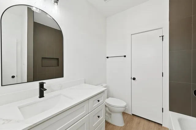 a bathroom with a granite countertop sink toilet and shower