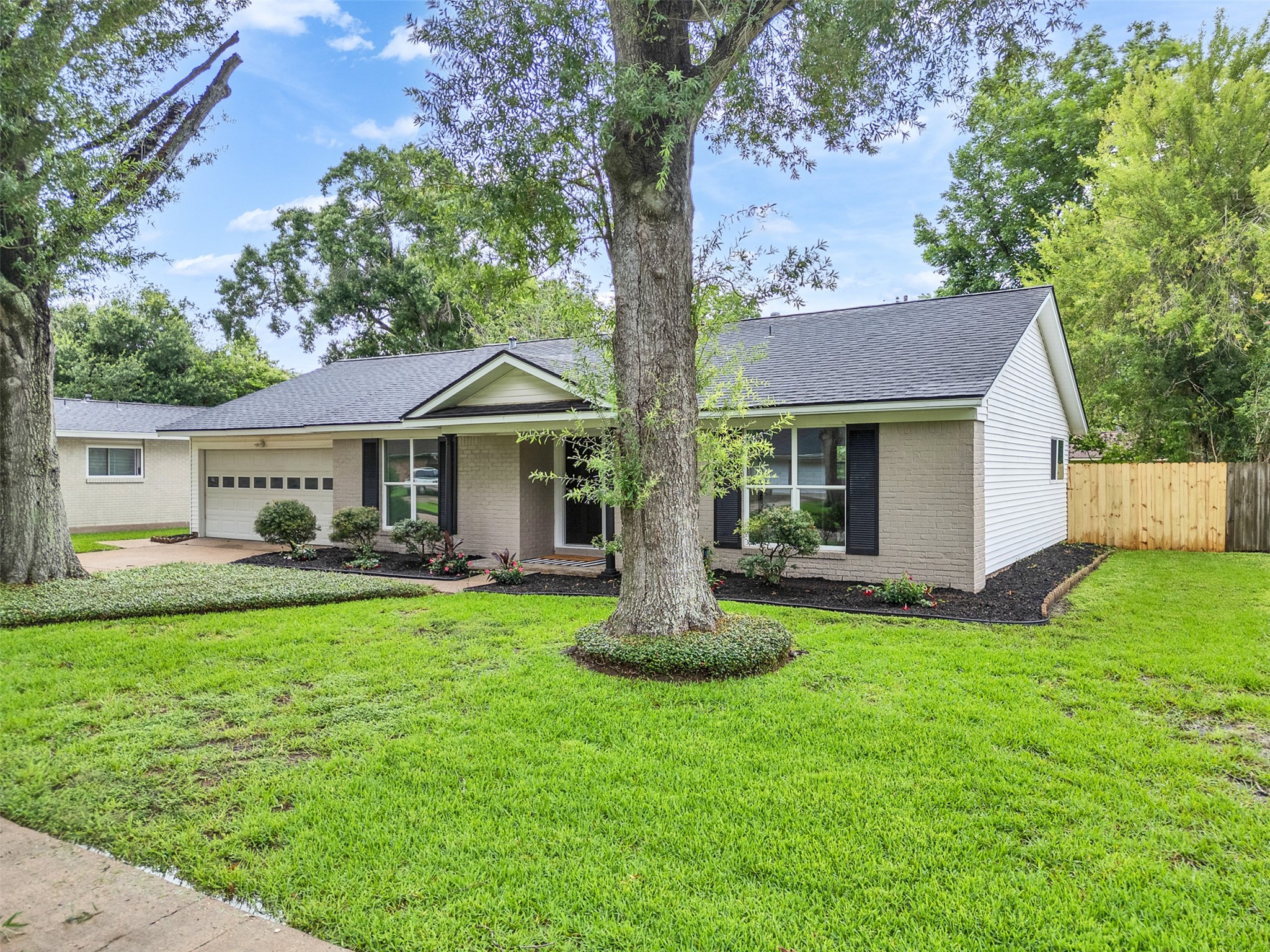 10315 Winding Trail Road La Porte, TX 77571 - Photo 3 of 24 Discover the charm of this beautiful home, featuring a lush green lawn, mature trees, and a welcoming facade that promises comfort and style.