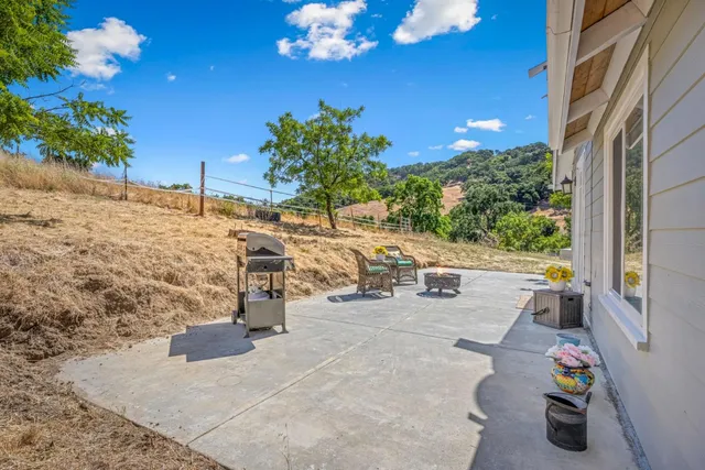 a view of a patio with a table and chairs and potted plants