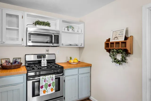 a kitchen with stainless steel appliances granite countertop a stove a microwave a sink and cabinets