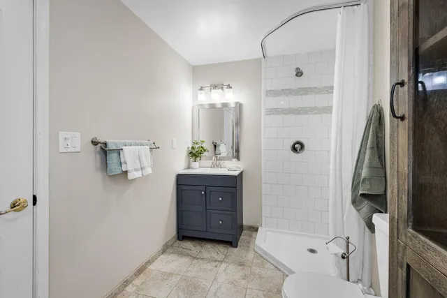 a bathroom with a tub shower vanity and a sink