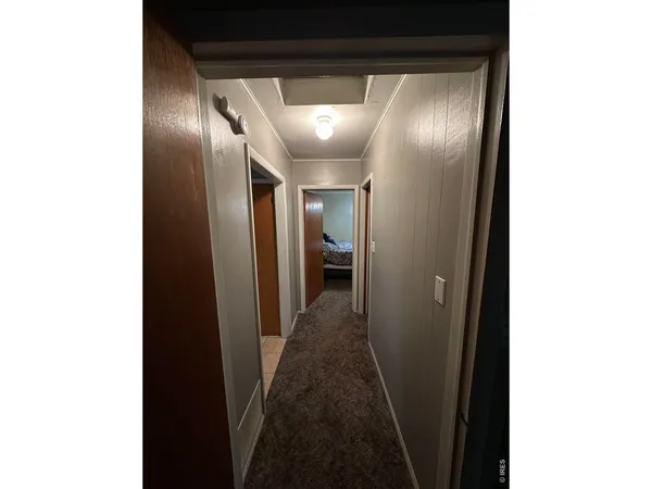a view of a hallway with a room that has a bathroom and a bathroom sink