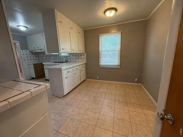 an empty room with a ceiling fan and a window